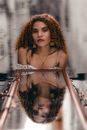Pretty Woman with Long Curly Hair Reflecting in Lying Mirror