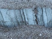 From above of rough rocky stone formation in dry fine sand at twilight