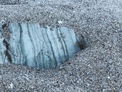 From above of droughty fine sand with cracked stone on seashore in evening
