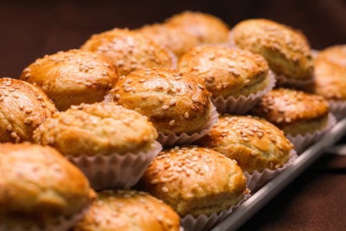 Delicious baked muffins with sesame seeds served on plate