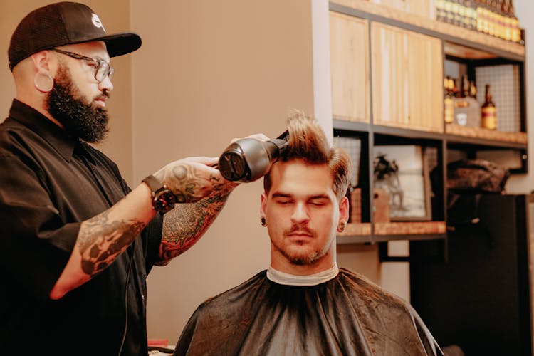 Barber Drying Hair Of Male Client In Salon