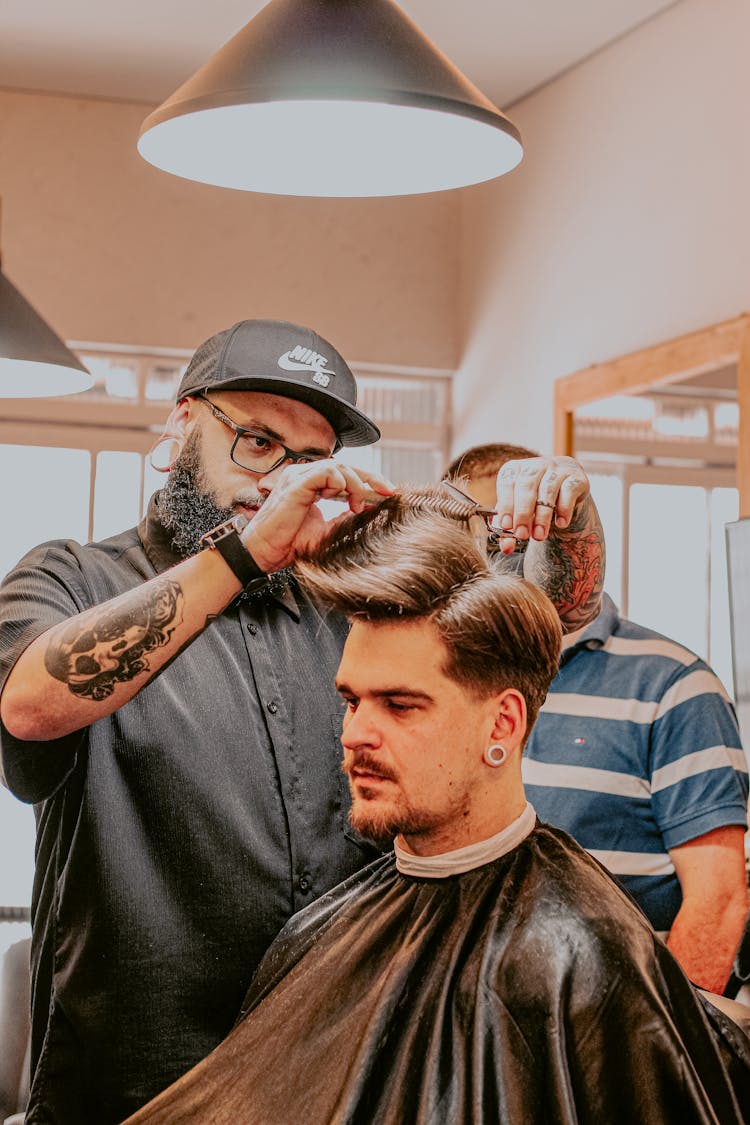 Bearded Barber Cutting Doing Haircut To Male Client In Salon