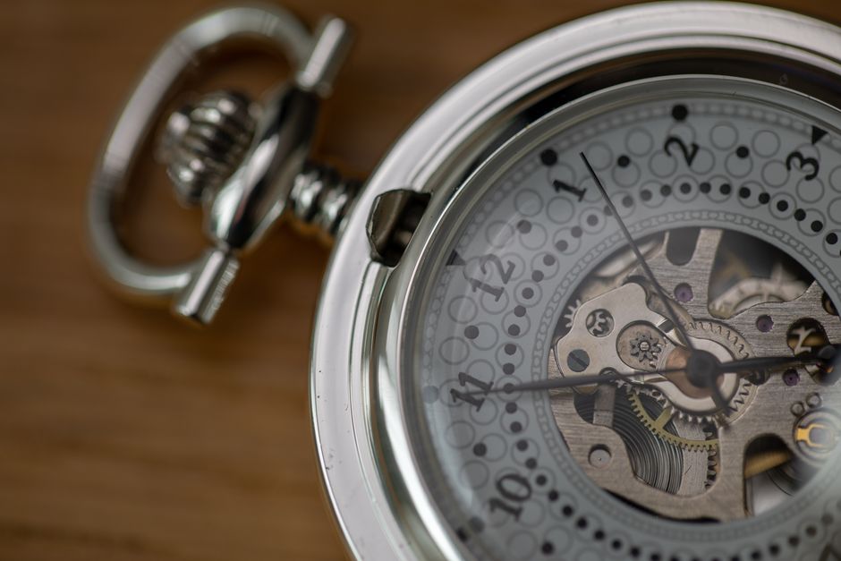 Detailed close-up of a silver skeleton pocket watch showcasing intricate gears and design.