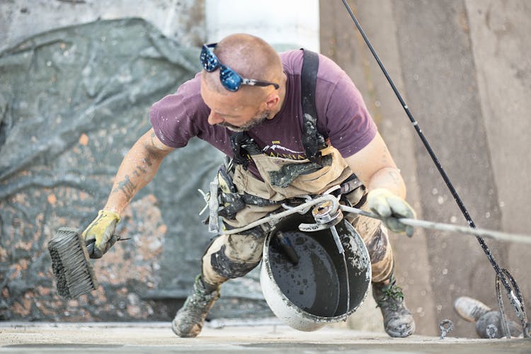 Worker Skim Coating Wall With Liquid Plaster