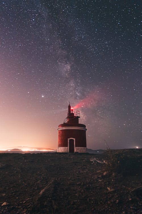 Free Lighthouse glowing on starry sky Stock Photo