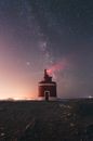 Lighthouse glowing on starry sky