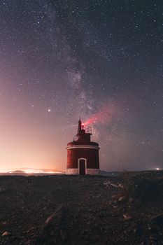 夜晚，红色灯塔在宁静的星空下静静矗立