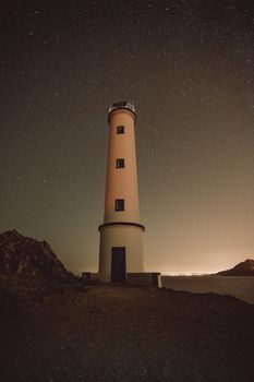 灯塔低矮，小窗朝向夜晚户外星空下的小路