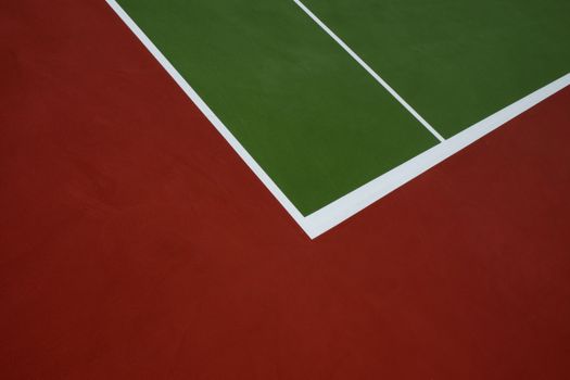 A minimalist abstract view of a vibrant tennis court with colorful lines.