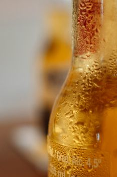 以特写垂直镜头拍摄带有冷凝物的清新啤酒瓶