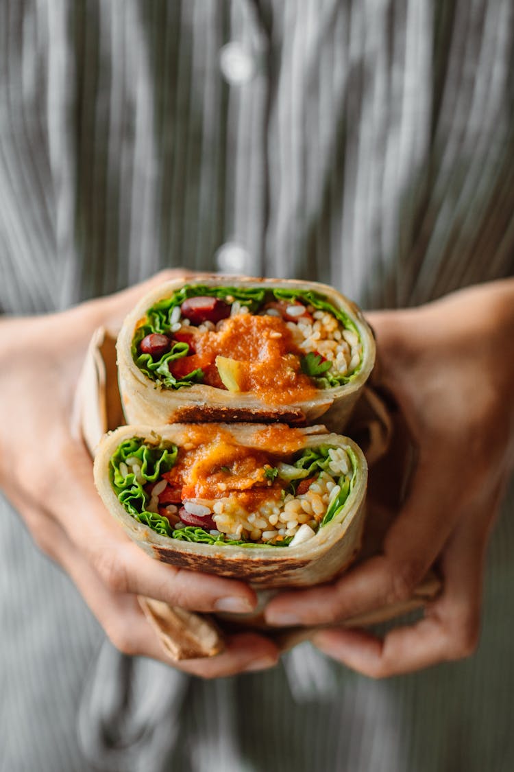 Person Holding Sliced Vegetable Wrap 