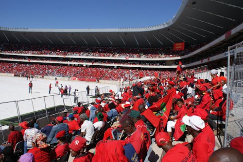 Crowd Wearing Red Shirts and Holding Red Flags 