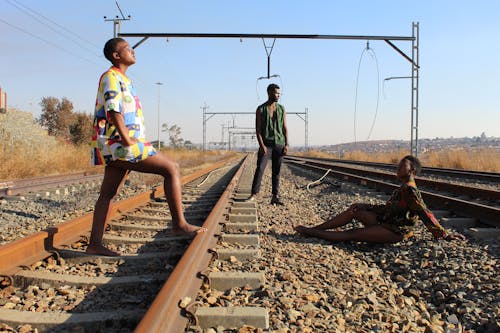 People Posing near the Rusty Railway Track 