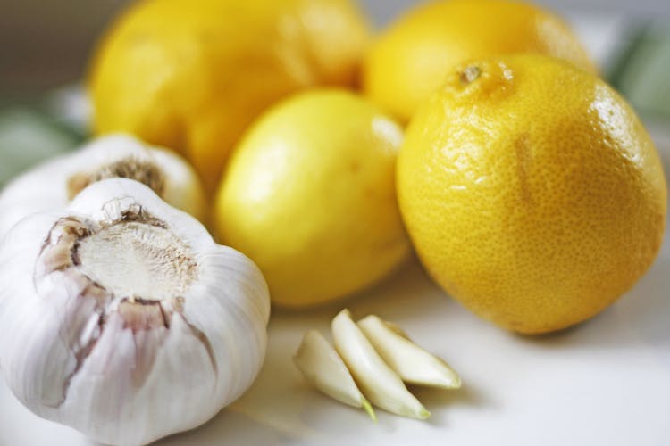 Garlic Bulbs Next To Yellow Lemons