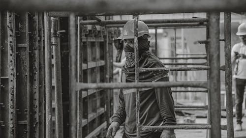 Grayscale Photo of a Man Working in Construction 