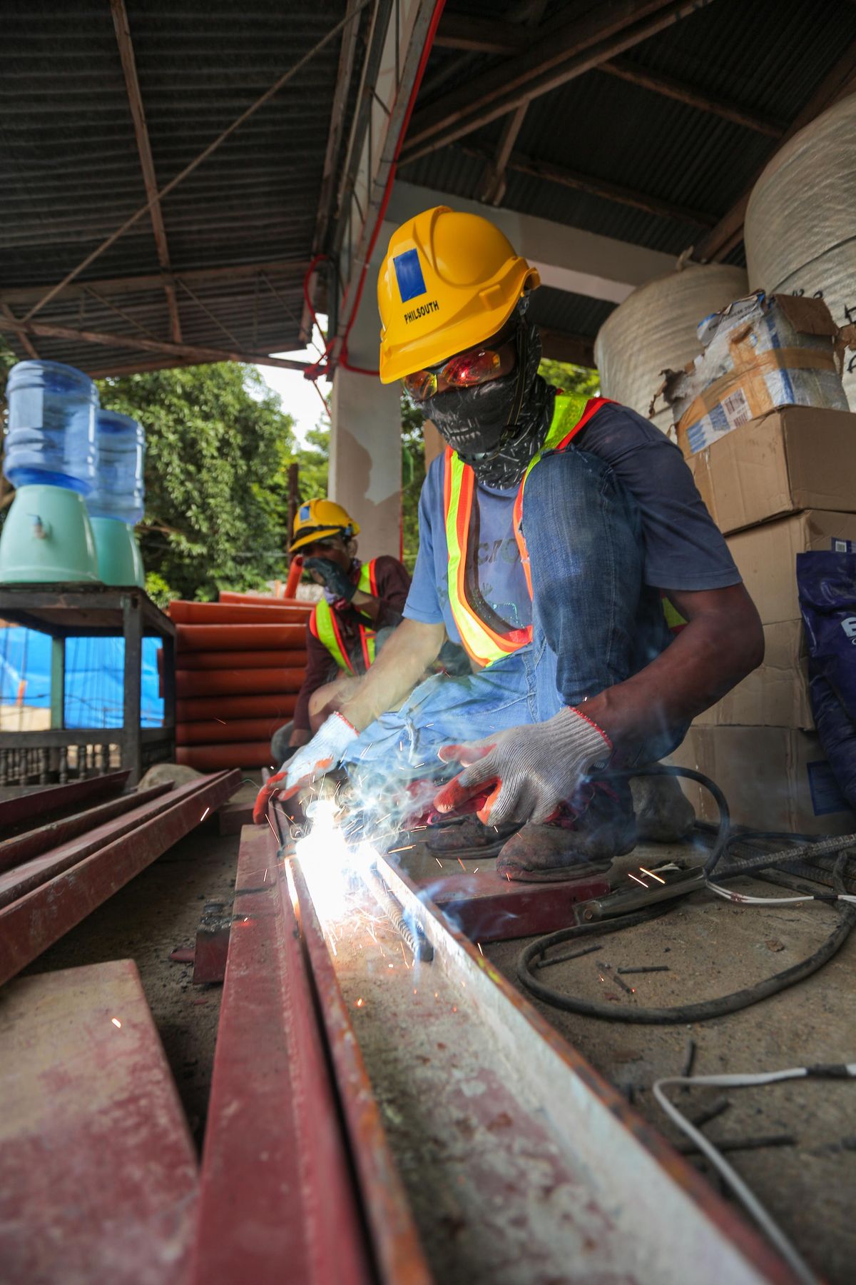 Construction worker welding metal beams with safety gear