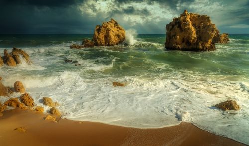 Free Epic seascape featuring dramatic waves and rugged rock formations under a stormy sky. Stock Photo