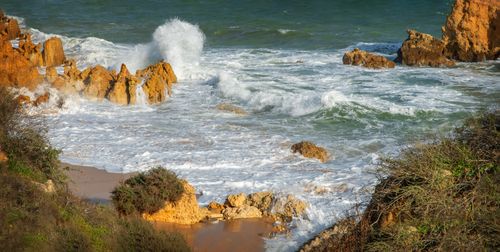 Free Powerful ocean waves crash against rugged rocks on a scenic coastal shoreline. Stock Photo