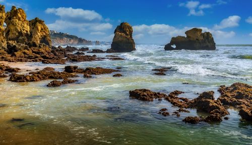 Free Captivating rocky seascape with dramatic ocean waves and a vibrant sky, perfect for nature enthusiasts. Stock Photo
