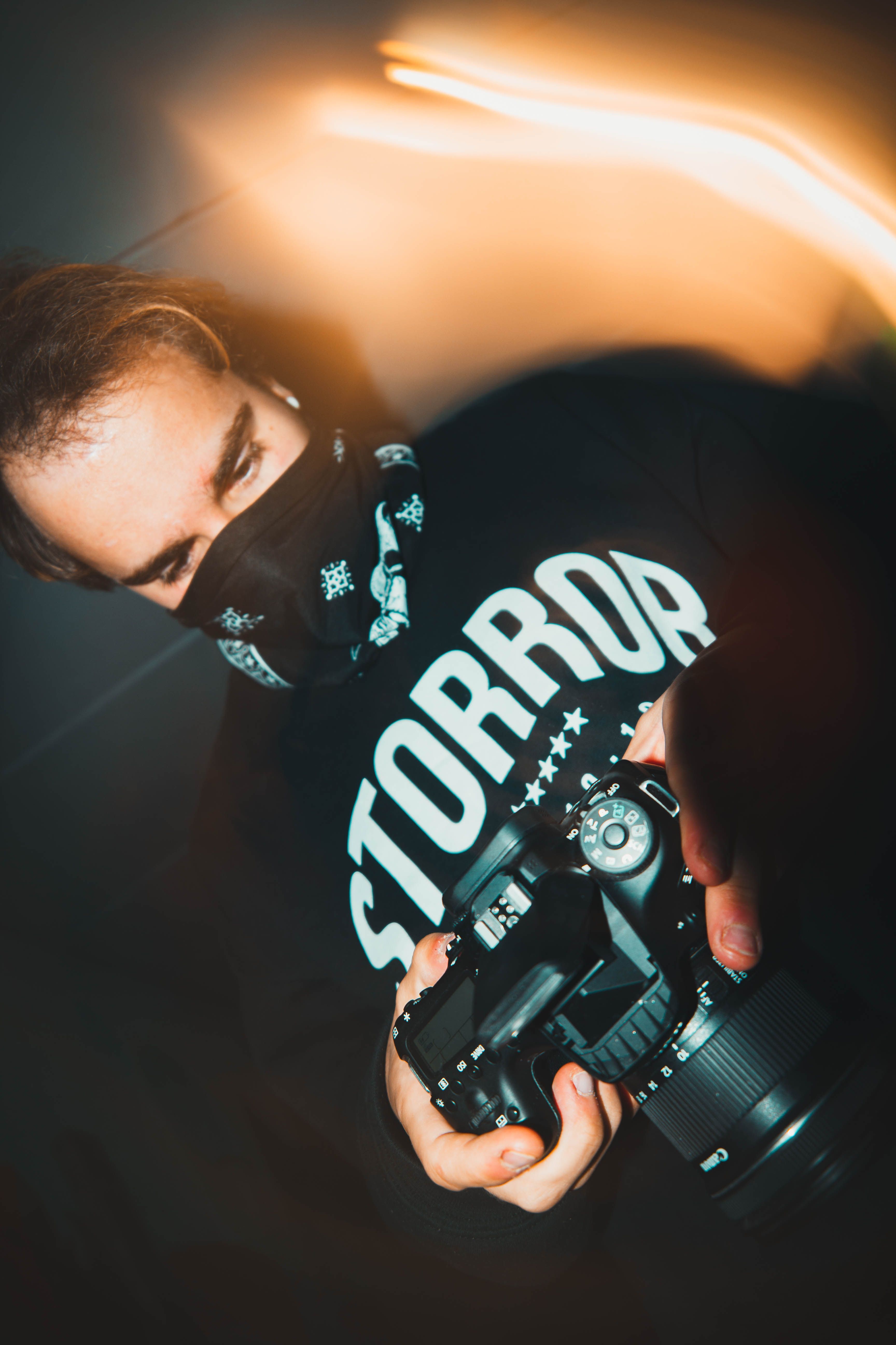A professional photographer holding a DSLR camera in Karlshamn, Sweden, with dynamic lighting effects.