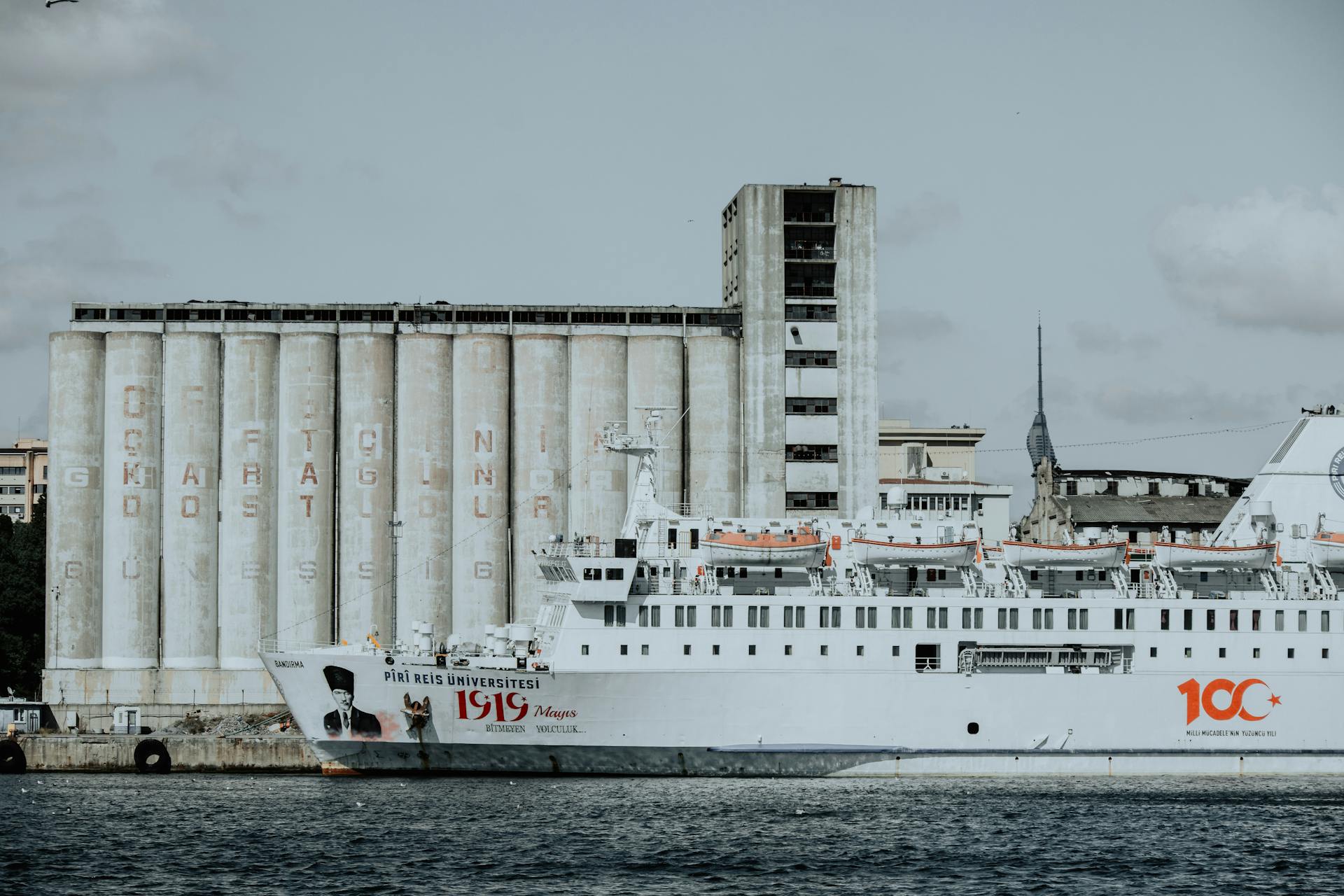 Piri Reis University ship docked in İstanbul, Türkiye, with a backdrop of industrial structures.