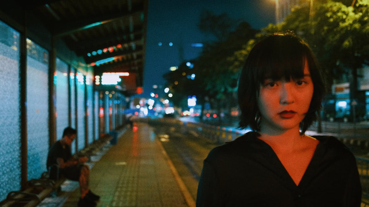 Young Asian woman on station at night
