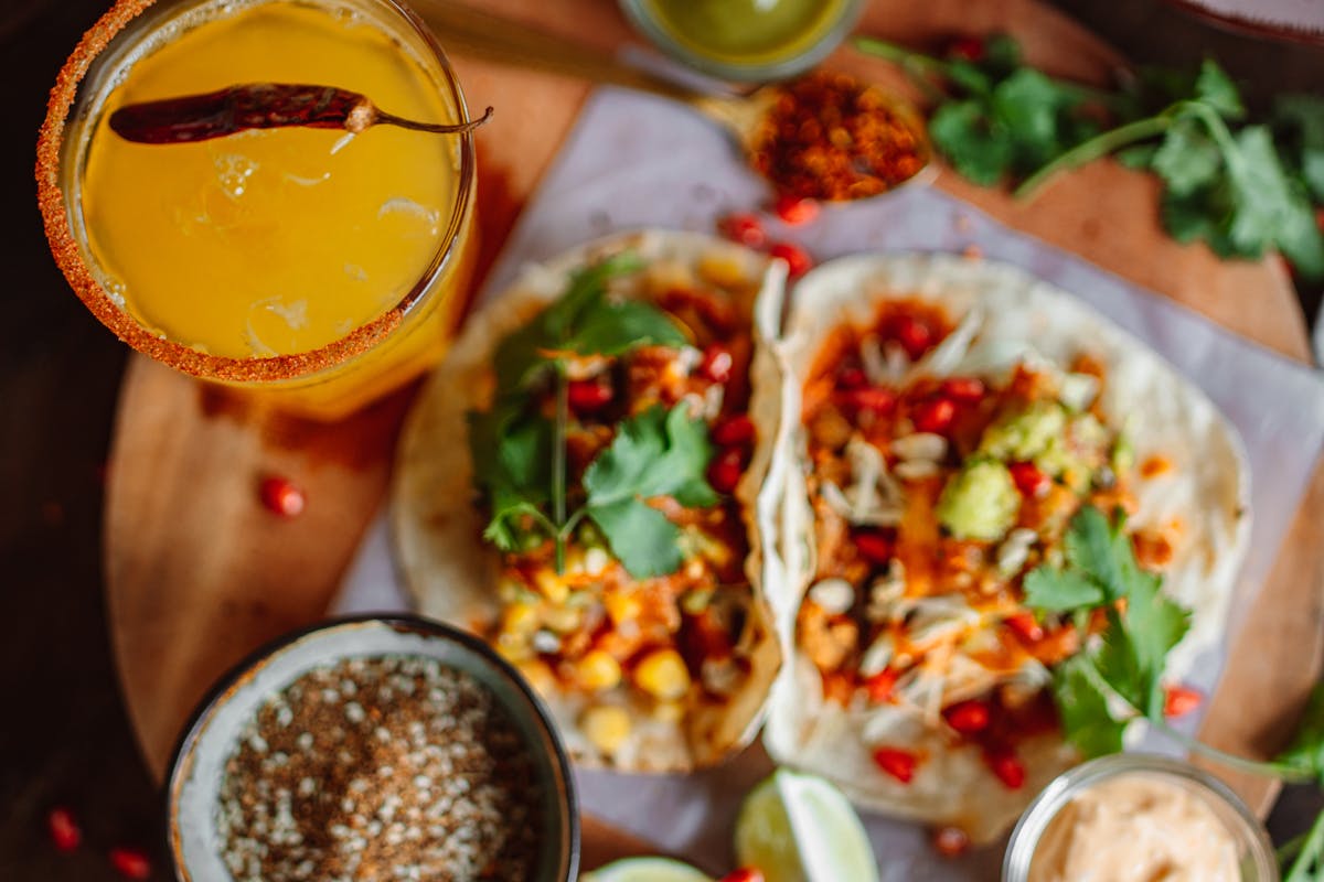 Shared snack board with vegetables, dips, bread, and olives in the center of a table