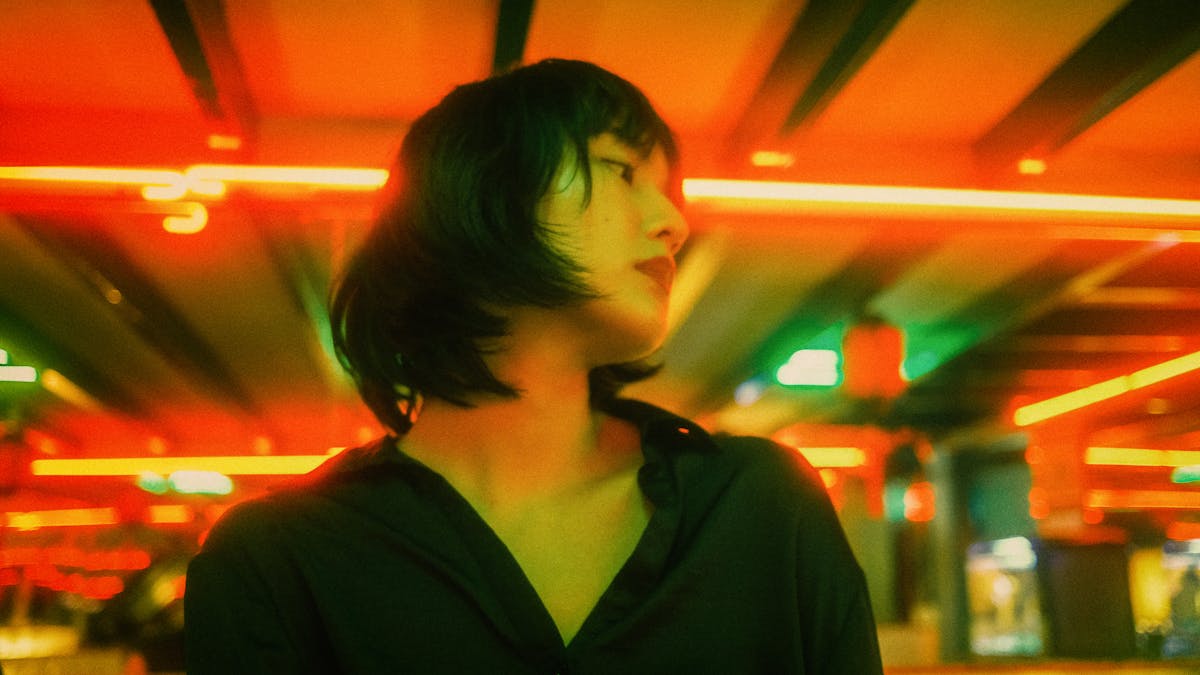 Person preparing a colorful salad bowl with vegetables and grains on a kitchen counter