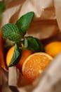 特写镜头展示纸袋里多汁的橙子和新鲜薄荷叶，凸显新鲜感