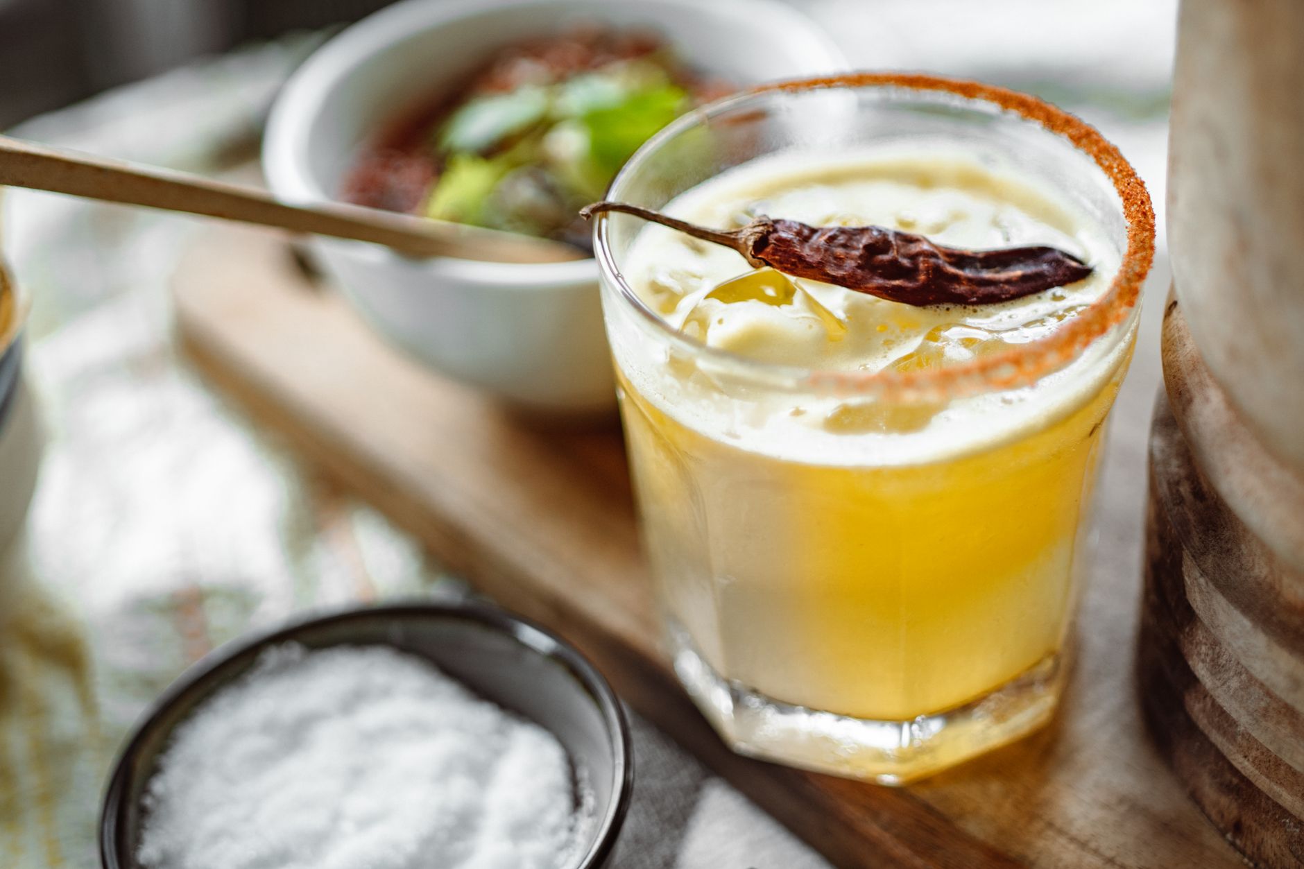 Margarita glass with chili powder rim and lime garnish on a bar