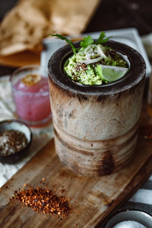 Free A rustic presentation of creamy guacamole with lime, served in a wooden bowl, perfect for a healthy snack. Stock Photo