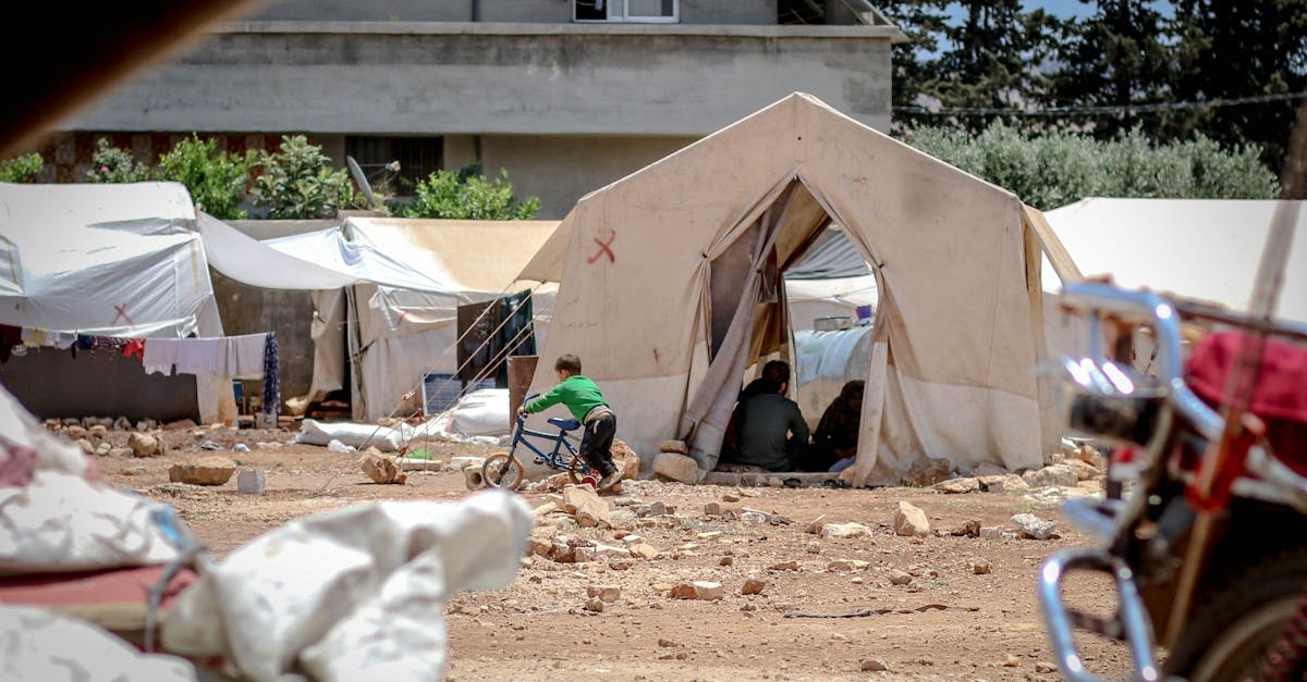Temporary fabric tents located on ground with garbage in poor district for refugee camp