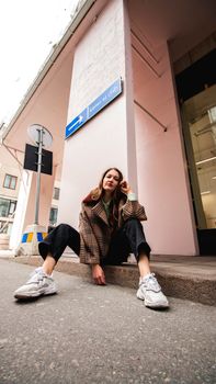Chic fashion model posing stylishly on a Stockholm street corner. Captivating urban vibe.
