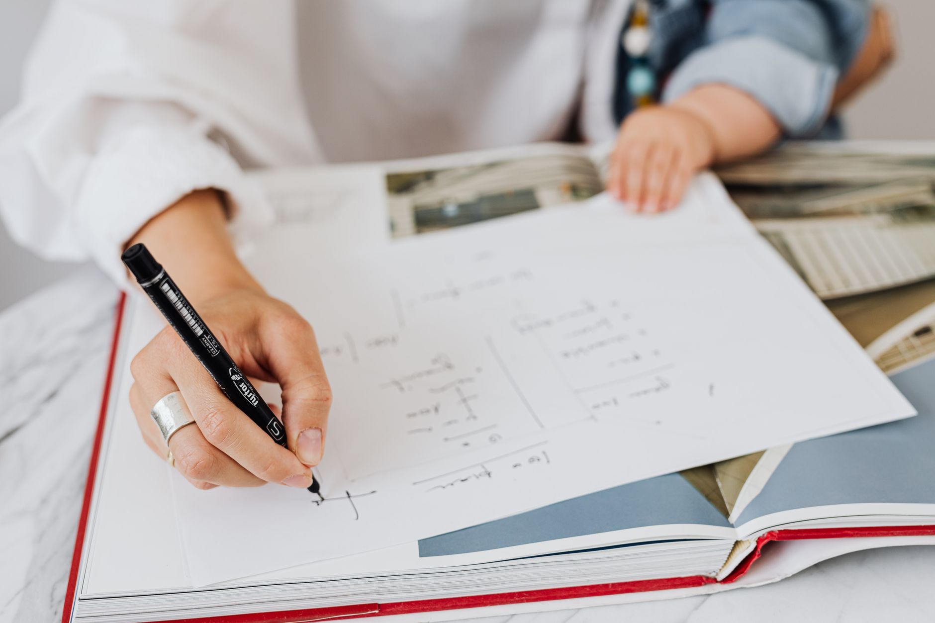 Hand filling out a cost-per-wear wardrobe planning worksheet