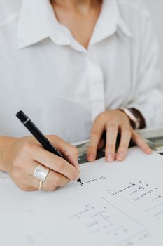 办公室环境中，一个人用笔在纸上写笔记的特写