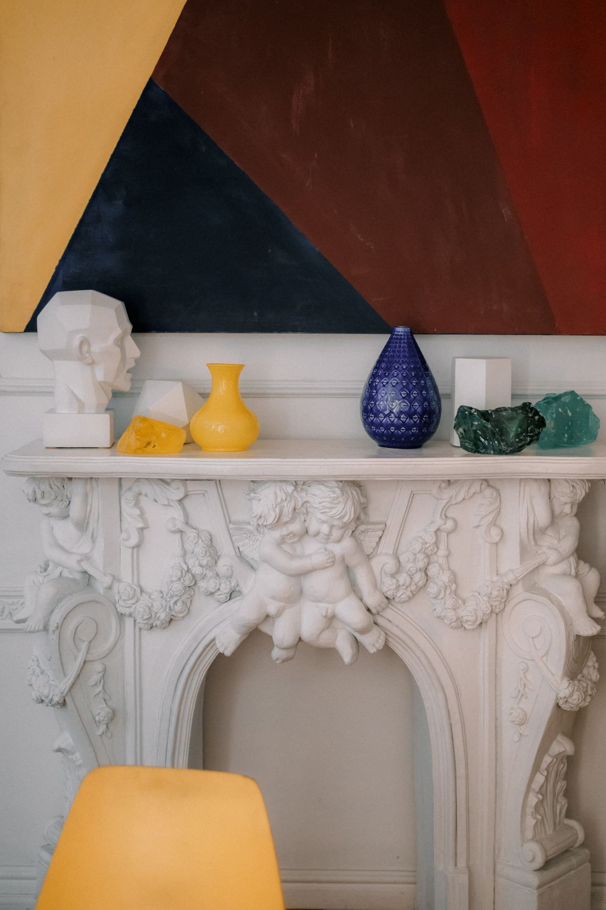 Stylish composition of various colorful decorative elements placed on classic styled shelf with bas reliefs Stock Photo.