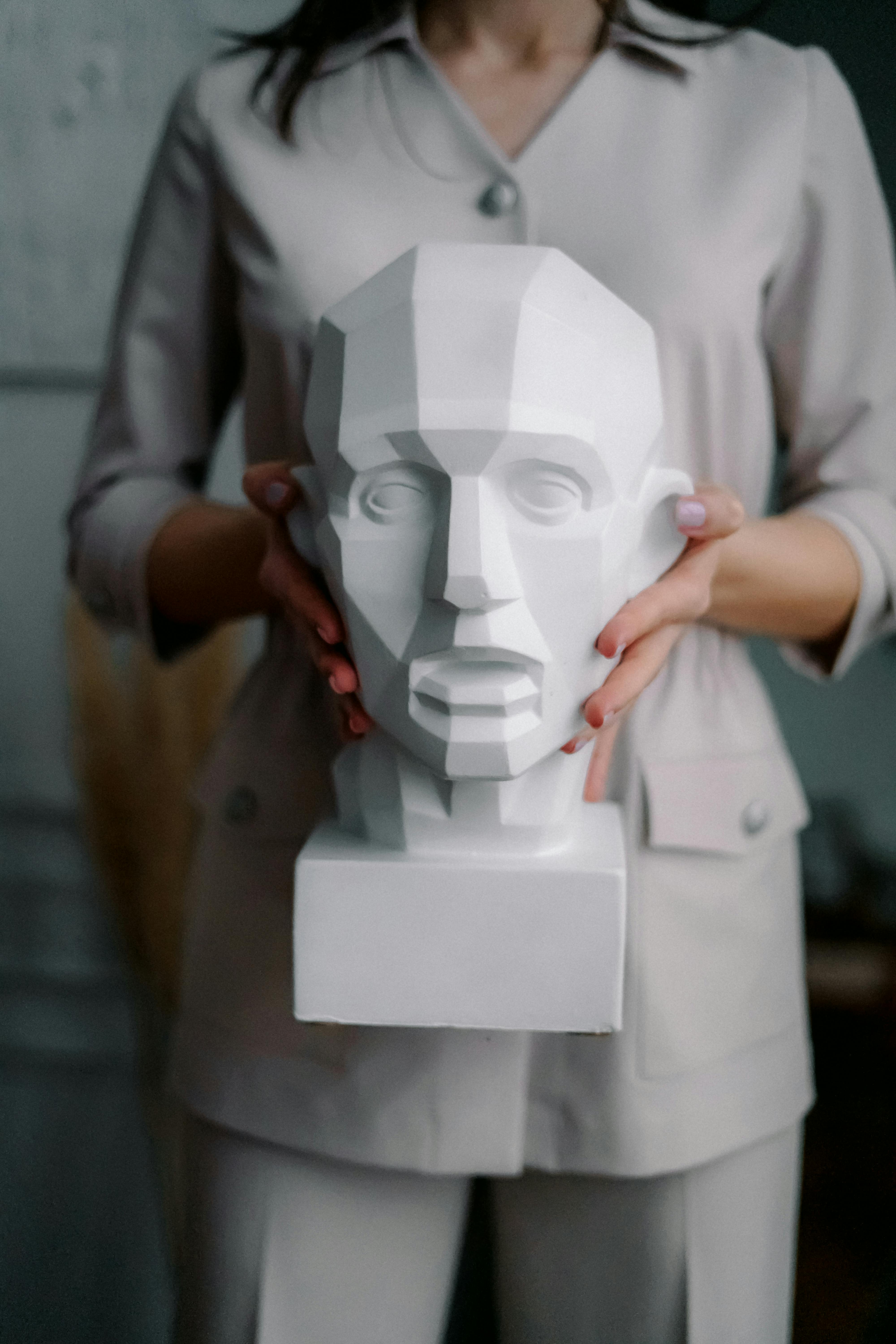 photo of person carrying a sculpture on her hands