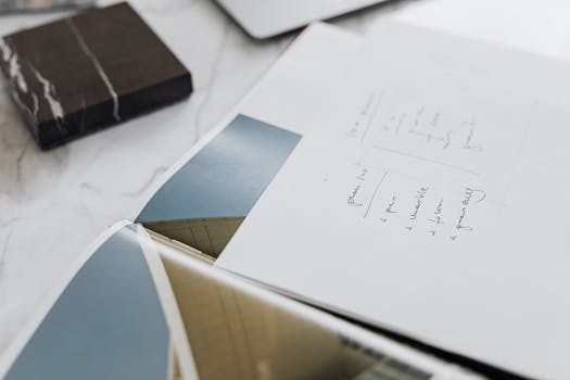 这是一张展示设计概念的建筑草图特写视图，拍摄于大理石办公桌上的纸张