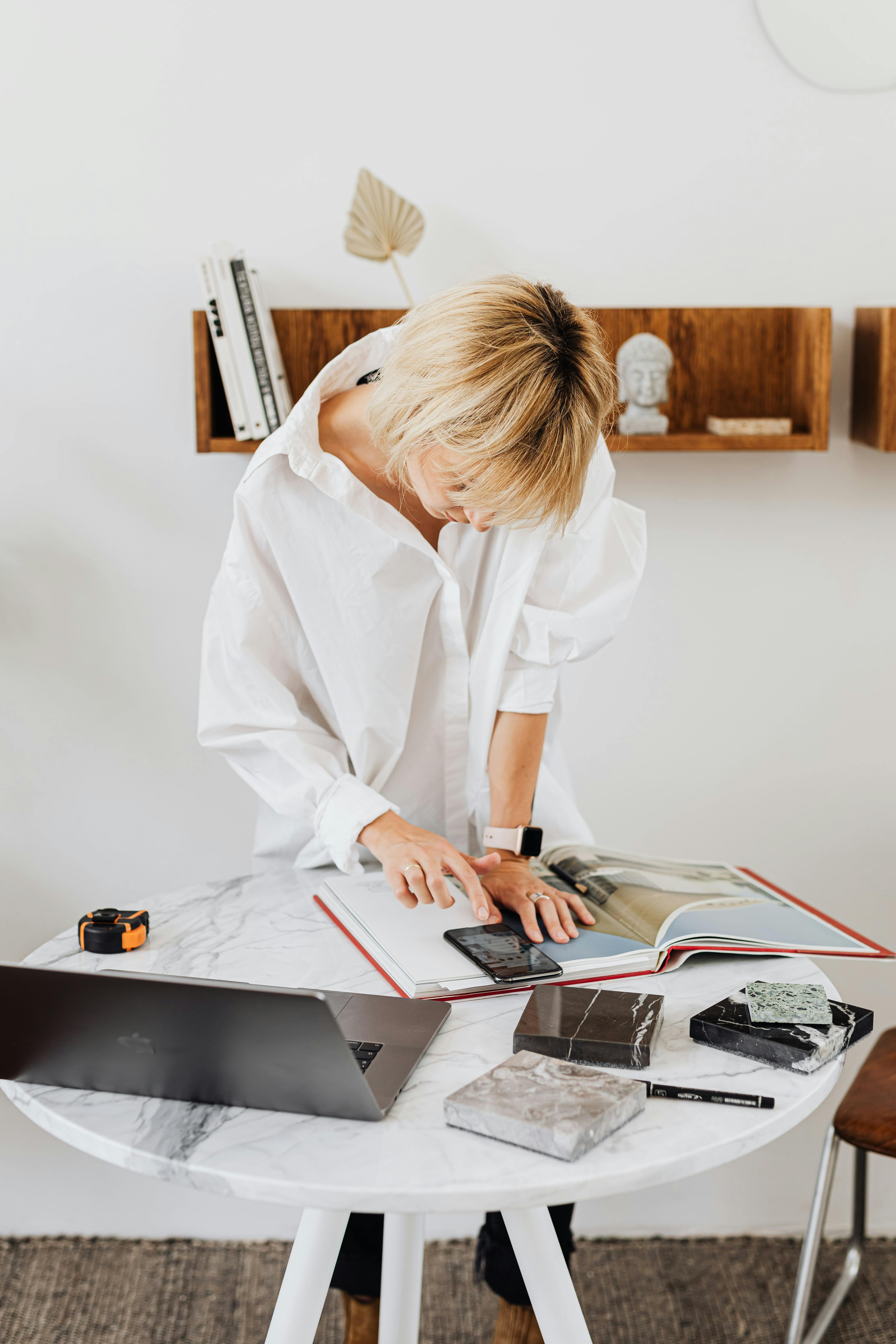 一位女士在明亮的办公室里检查桌子上的建筑项目