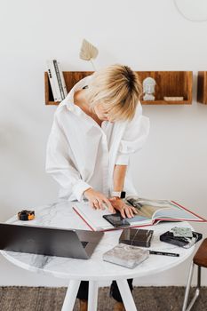 一位女士在明亮的办公室里检查桌子上的建筑项目