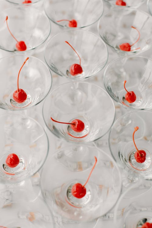 Free Refreshing alcoholic drinks with cherries served on white table Stock Photo