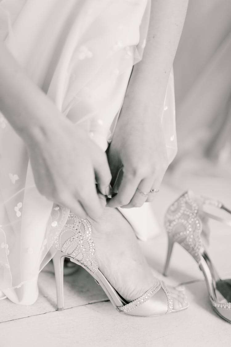 Elegant Bride In Dress Fastening Wedding Shoes