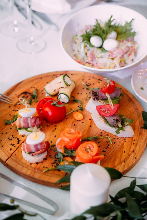 Free From above of delicious rolls of fresh vegetables and canapes with meat on banquet table Stock Photo