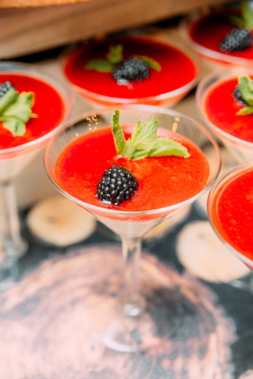 Delicious dessert in cocktail glasses with berries and mint leaves