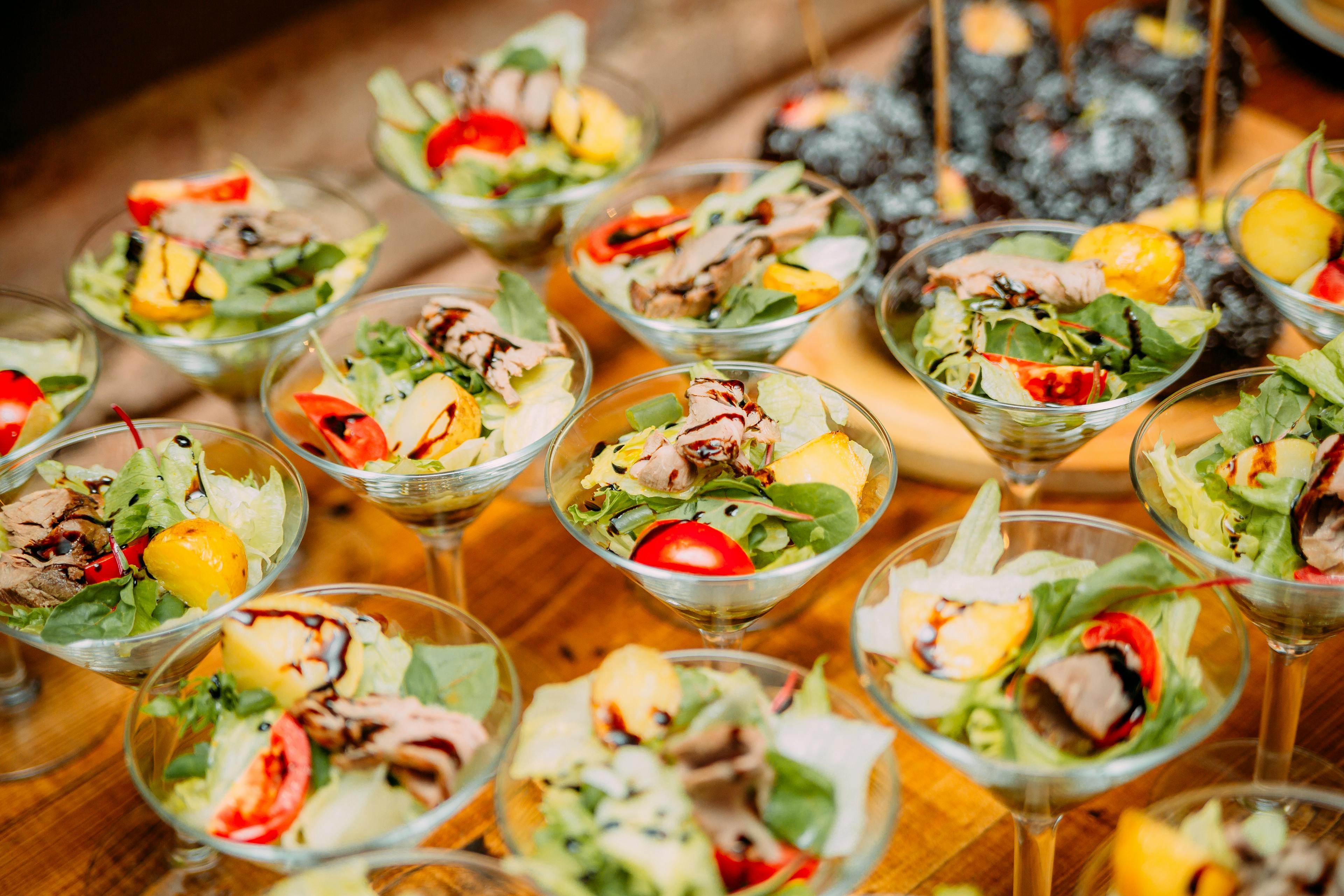 From above of served glasses with fresh vegetables placed on table in restaurant for catering