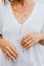 Woman in White Scoop Neck Shirt Wearing Gold Necklace