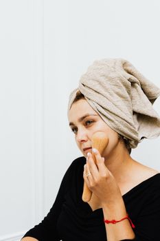 Woman indulging in skincare routine with a face massager at home