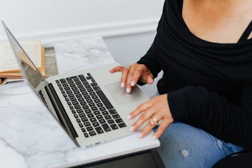 Free Woman in Black Long Sleeves Using a Laptop Stock Photo
