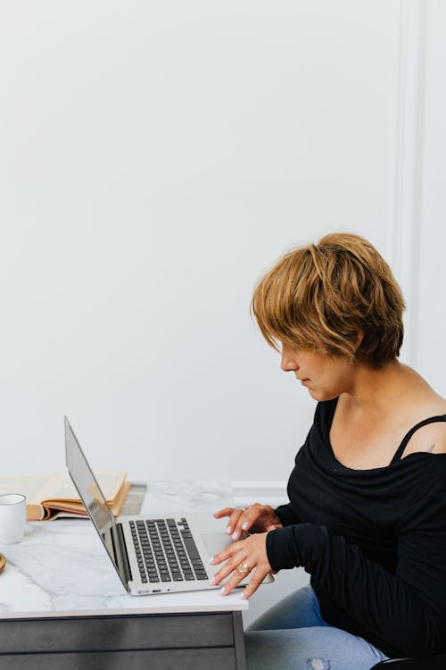 Woman in Black Tank Top Using Macbook Pro