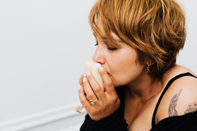 Woman In Black Top Smelling A Soap Bar